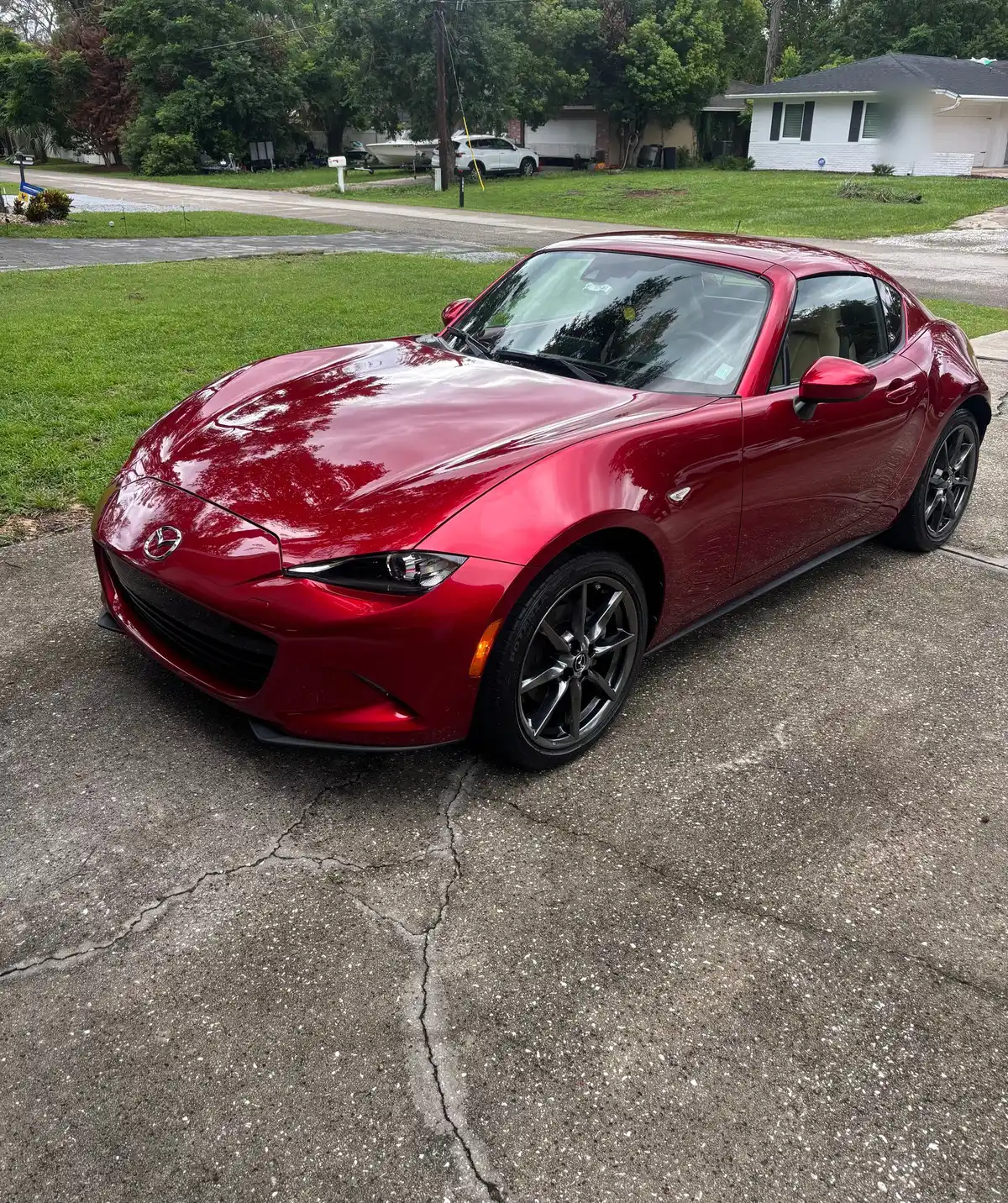 Red Mazda MX-5 Miata RF from the front, freshly detailed in the driveway