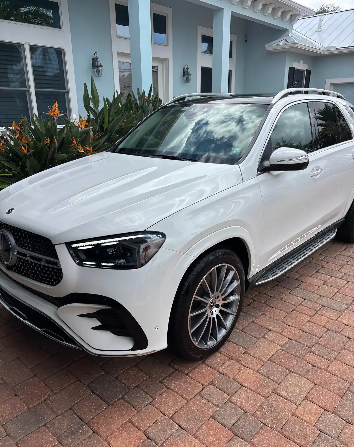 White Mercedes-Benz GLE with a bright, clean finish outside a Florida home
