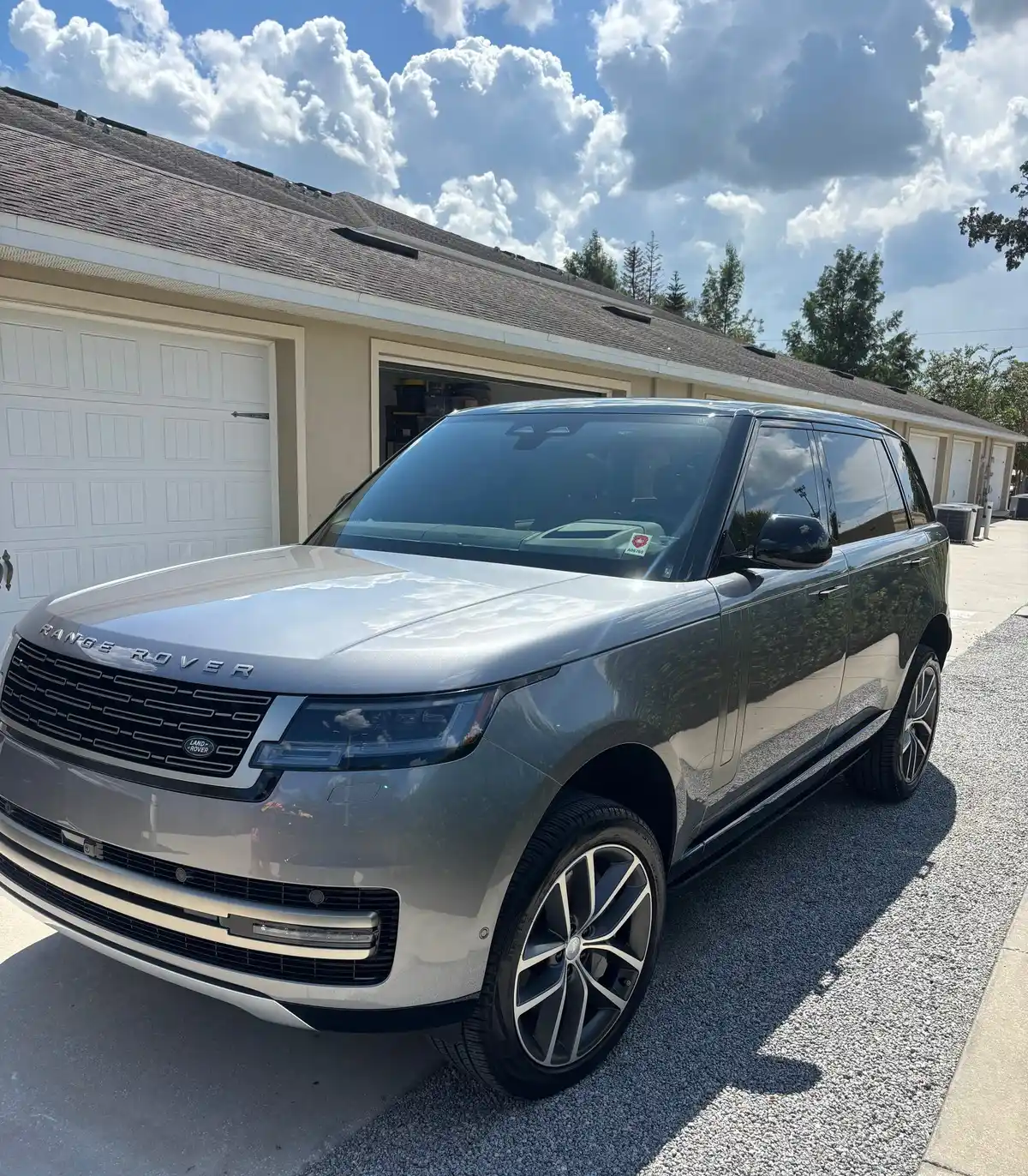 Gray Range Rover after a detail, parked in front of a garage