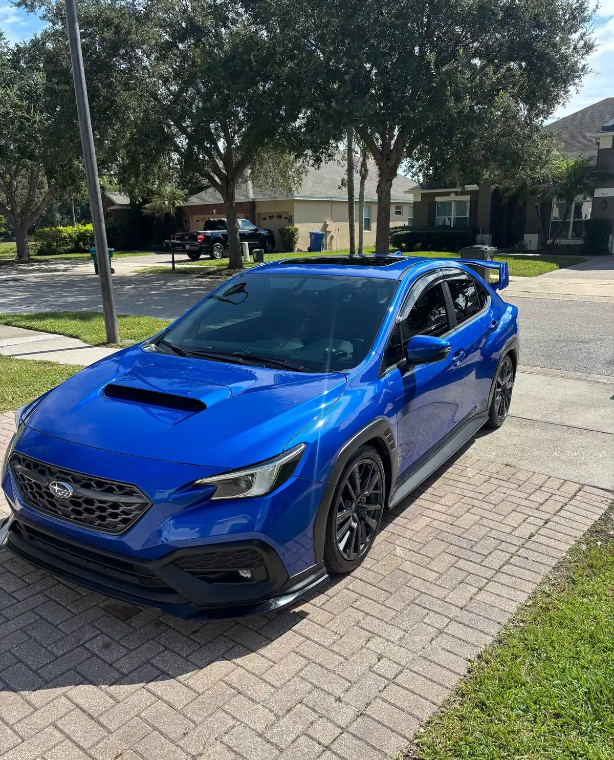 Blue Subaru WRX after a detail, parked on a brick driveway