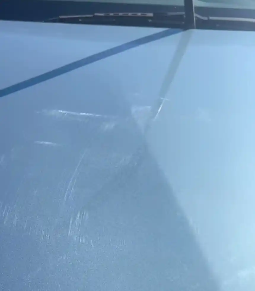 Blue Toyota RAV4 hood partway through a one-step paint correction: scratches on the uncorrected left side, a clearer finish on the corrected right